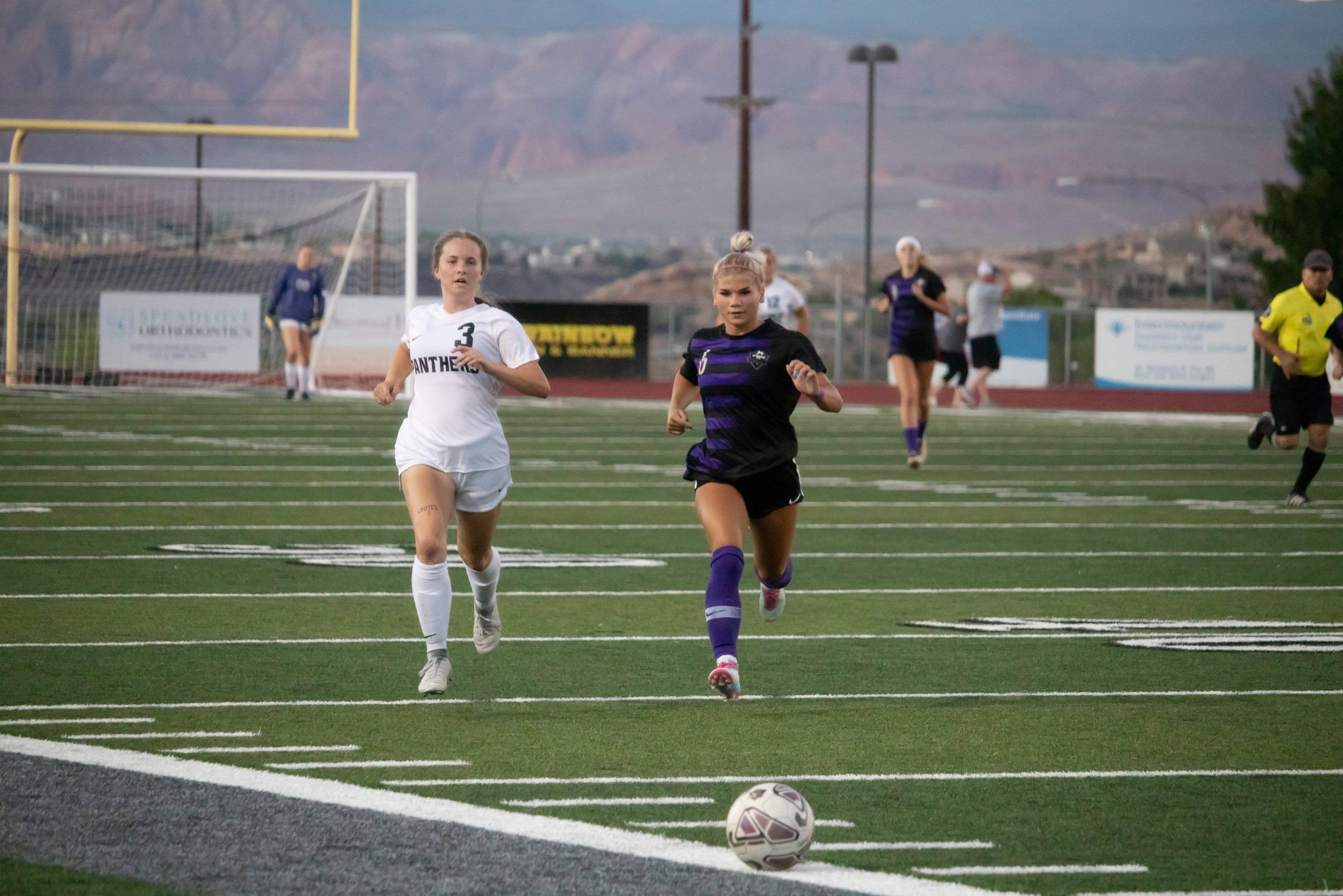 girls soccer players chasing ball